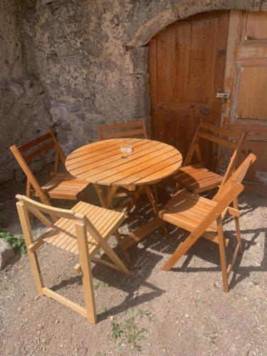 a wooden table and chairs and a wooden door at maison de vigneron in Mareugheol