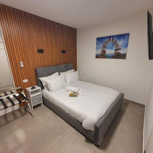 a bedroom with a large bed in a room at Ryo 19 דירה במלון בוטיק 2 דקות מטיילת בת ים in Bat Yam
