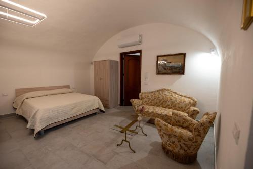 a bedroom with a bed and a couch and a chair at Le 4 Stagioni-nelcuorediCorleone in Corleone