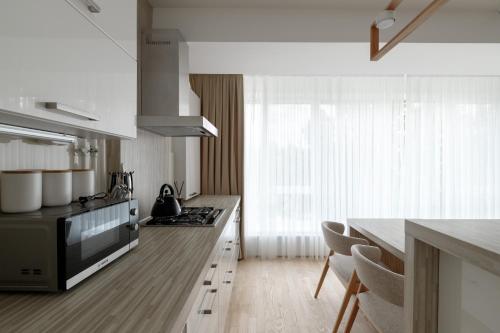a kitchen with a stove and a counter with chairs at Dosoftei Residence in Chişinău