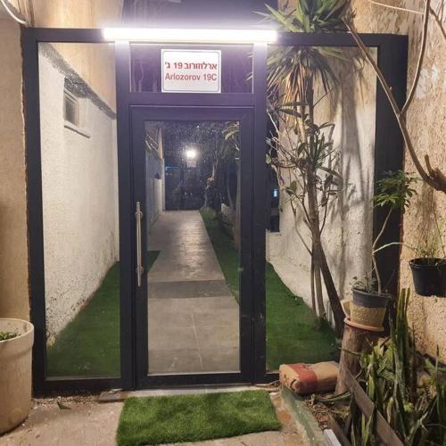 an entrance to a building with a sign on the door at Ryo 20 דירה במלון בוטיק 2 דקות מטיילת בת ים in Bat Yam