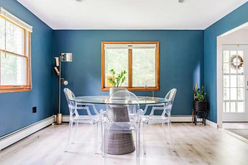 a dining room with blue walls and a glass table and chairs at Eldred Manor in Eldred
