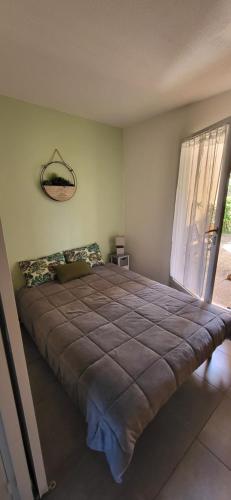 une chambre avec un grand lit avec une grande fenêtre dans l'établissement BLEU BOUCHAREL, à Saint-Aygulf