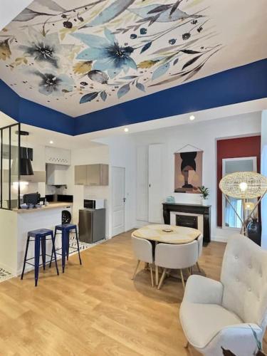 - un salon avec un plafond muni d'une table et de chaises dans l'établissement Au Jasmin de Miss K, à Bourg-en-Bresse