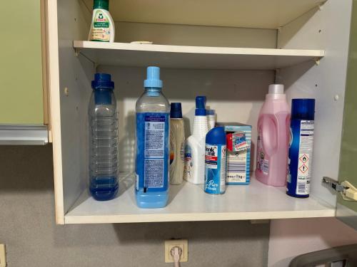 a shelf with bottles of water and other bathroom items at Familyhouse Cologne in Hürth