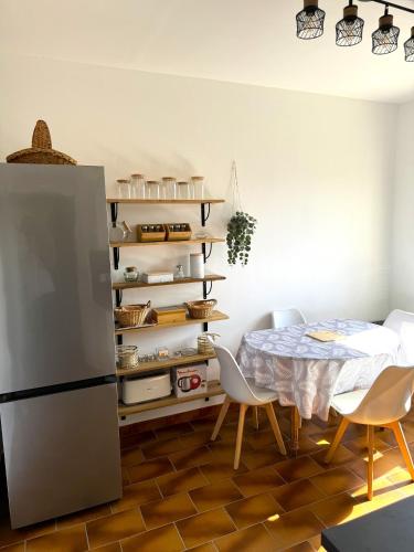 une cuisine avec une table et un réfrigérateur dans l'établissement La Douceur des Alpilles, à Saint-Rémy-de-Provence