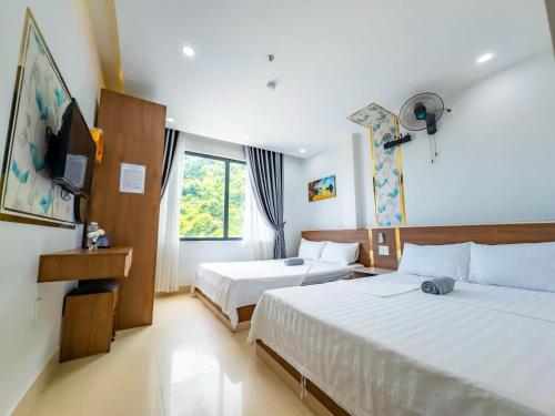 a hotel room with two beds and a television at Duc Duy Hotel Cat Ba in Cat Ba