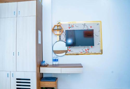 a room with a tv and a mirror on the wall at Duc Duy Hotel Cat Ba in Cat Ba