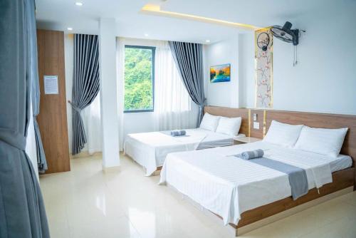 a hotel room with two beds and a couch at Duc Duy Hotel Cat Ba in Cat Ba