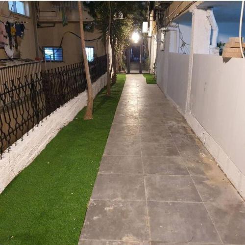 a sidewalk with a tree on the side of a building at Ryo 23 דירת נופש עם ג'קוזי 2 דקות מטיילת בת ים in Bat Yam