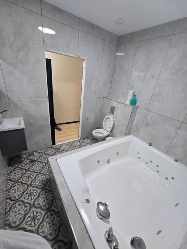 a bathroom with a white tub and a toilet at Ryo 23 דירת נופש עם ג'קוזי 2 דקות מטיילת בת ים in Bat Yam