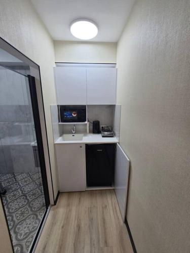 a small kitchen with a sink and a microwave at Ryo 23 דירת נופש עם ג'קוזי 2 דקות מטיילת בת ים in Bat Yam