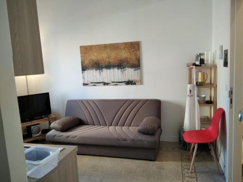 salon z kanapą i czerwonym krzesłem w obiekcie Chiarini22 Apartments w mieście Neapol