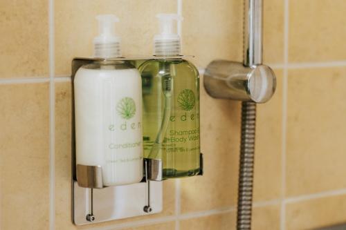 two bottles of soap are hanging on a wall at Dux Farm Retreat - 2 bed dog friendly cottage, near Bude in Holsworthy