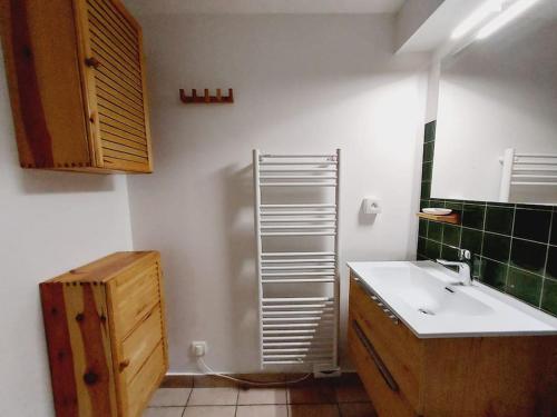 La salle de bains est pourvue d'un lavabo blanc et d'un mur en carrelage vert. dans l'établissement LE COSY à Aime La Plagne, à Aime La Plagne