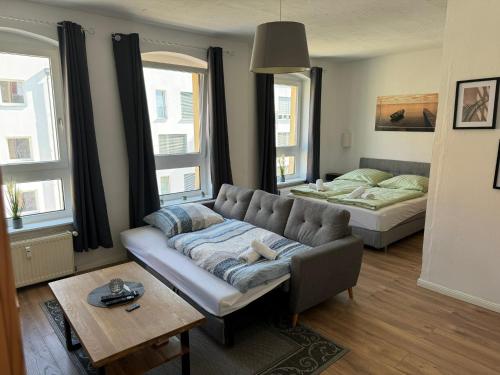 a living room with a couch and a bed at Altbauapartment in Wassernähe und Magenta TV in Brandenburg an der Havel