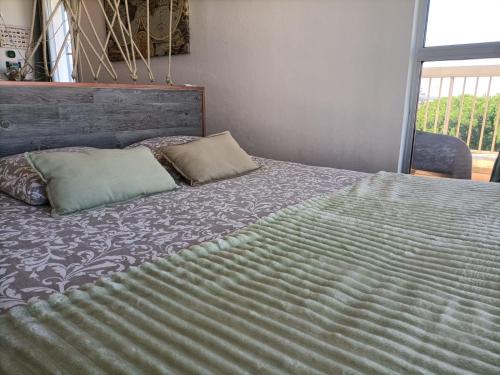 a bed with two pillows on top of it at Le Sémaphore - studio climatisé, grande terrasse vue mer - parking, wifi in La Grande Motte