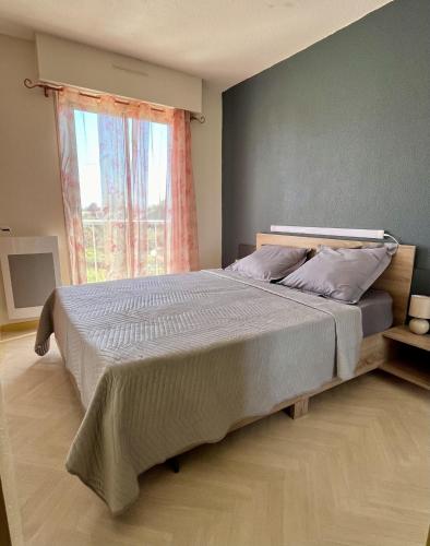 un grand lit dans une chambre avec une fenêtre dans l'établissement les villageoises, au Barcarès