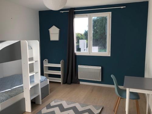 - une chambre avec des murs bleus, un bureau et des lits superposés dans l'établissement Maison de campagne meublée, à Issac