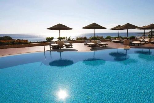 a large swimming pool with chairs and umbrellas at Elisir SPA & Hotel at Sheikh coast in Sharm El Sheikh