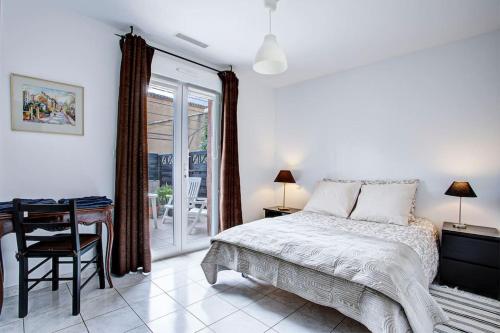 une chambre avec un lit, une table et un bureau dans l'établissement Villa Neptune jardin garage, à Montady