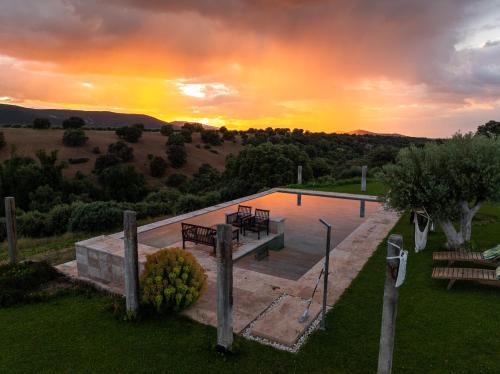 ein Swimmingpool mit einem Sonnenuntergang im Hintergrund in der Unterkunft CORK VALLEY - Pet Friendly & Only Adults in Hontanar