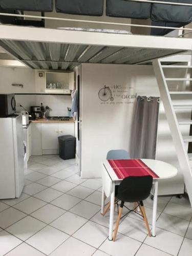 - une cuisine avec une table et un lit dans une chambre dans l'établissement Le Chateau, à Rambouillet