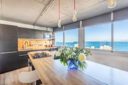 une cuisine avec une grande table en bois et des fleurs. dans l'établissement Dream Ocean View with Balcony Close to Beach, à Marseille