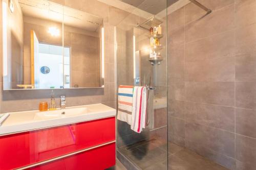 La salle de bains est pourvue d'un lavabo et d'une douche avec des placards rouges. dans l'établissement Dream Ocean View with Balcony Close to Beach, à Marseille