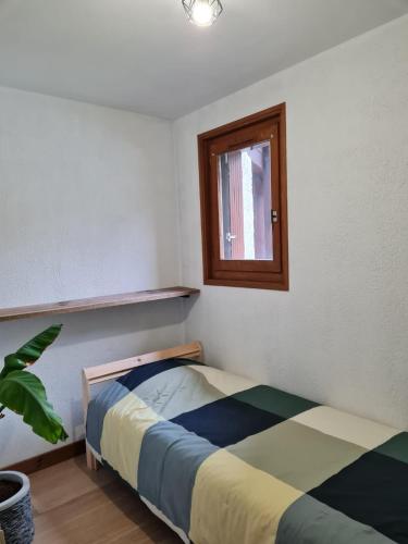 une chambre avec un lit et une fenêtre dans l'établissement Le refuge, à Samoëns