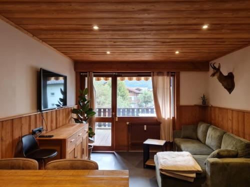 un salon avec un canapé et une table dans l'établissement Le refuge, à Samoëns