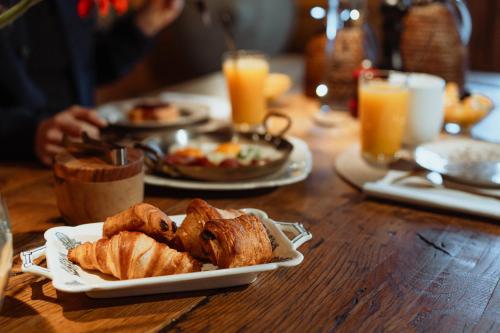 een houten tafel met borden met gebak en sinaasappelsap bij Chalet 1864 in Le Grand-Bornand