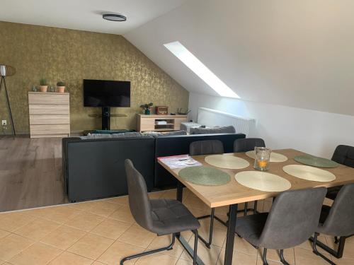 a dining room with a table and a couch at Apartmán Stará cihelna in Klatovy