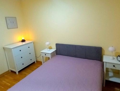 a bedroom with a large purple bed and a dresser at Vrnjački Kos in Vrnjačka Banja