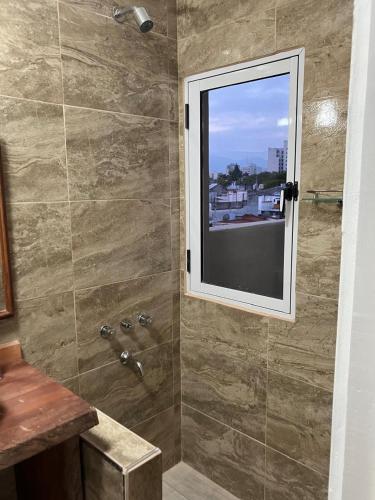 a bathroom with a shower with a window at Opera Apart Suites in Salta