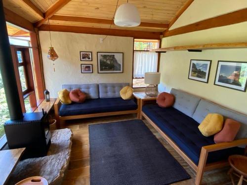 a living room with a blue couch in a room at Chalés Aiu 2 in Aiuruoca