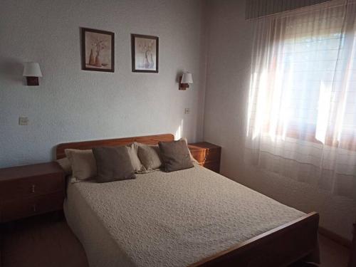 a bed in a bedroom with a window and a bed sidx sidx sidx at Casa en Barrio Privado Hipocampo in Villa Gesell
