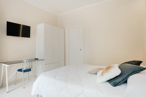 a white bedroom with a bed with pillows and a desk at Eco Lux Relais in Campobasso