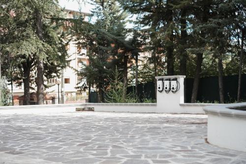 a bench in a park with trees and a building at Eco Lux Relais in Campobasso