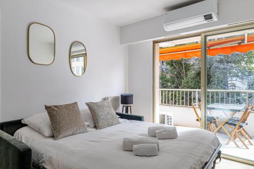 une chambre avec un grand lit et un balcon dans l'établissement CANNES 2 P avec terrasse PROCHE Hôtel Martinez, à Cannes