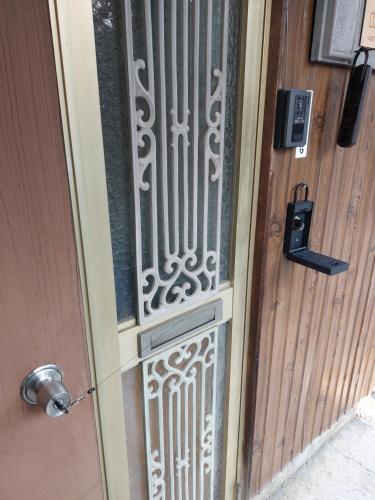 a door with a wrought iron gate on it at つきびとはうす in Satte