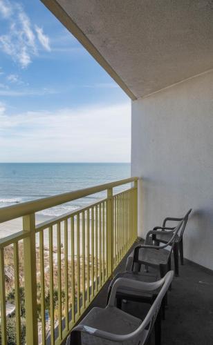 a row of chairs on a balcony overlooking the beach at Baywatch Resort in Myrtle Beach