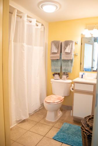a bathroom with a toilet and a sink and towels at Baywatch Resort in Myrtle Beach