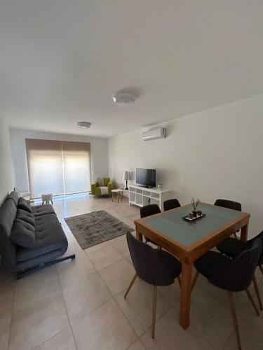 een woonkamer met een tafel en een bank bij Apartamento Rota do Sol in Armação de Pêra