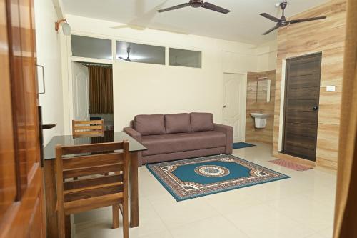 a living room with a couch and a table at Gokulam By Upasana in Guruvāyūr