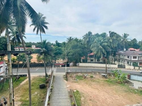 a street with palm trees on the side of a road at Gokulam By Upasana in Guruvāyūr