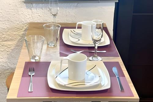 a table with white plates and silverware on it at Súper Apartamento central en Casa Colonial Bogotá in Bogotá