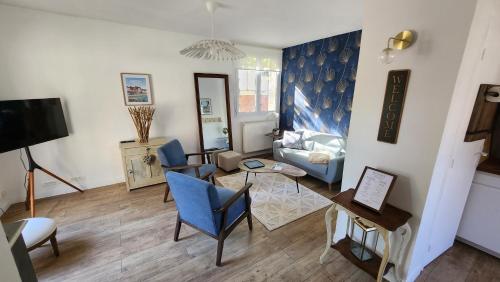 a living room with a couch and a table at Les Hortensias Roses Duplex in Amiens