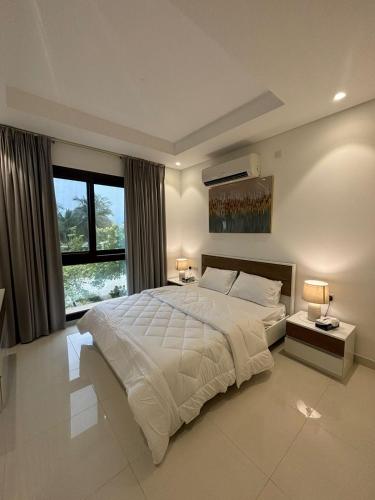 a bedroom with a large bed and a large window at Hawana VIP Appartment in Ma‘mūrah