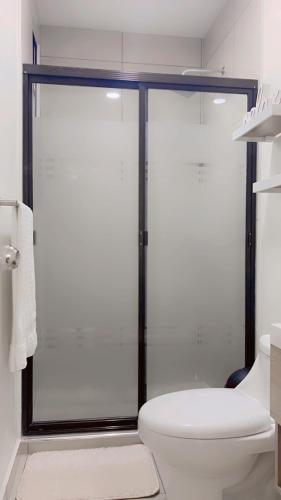 Un baño con inodoro y ducha de cristal. en Stylish house close to tourist attractions, en La Libertad
